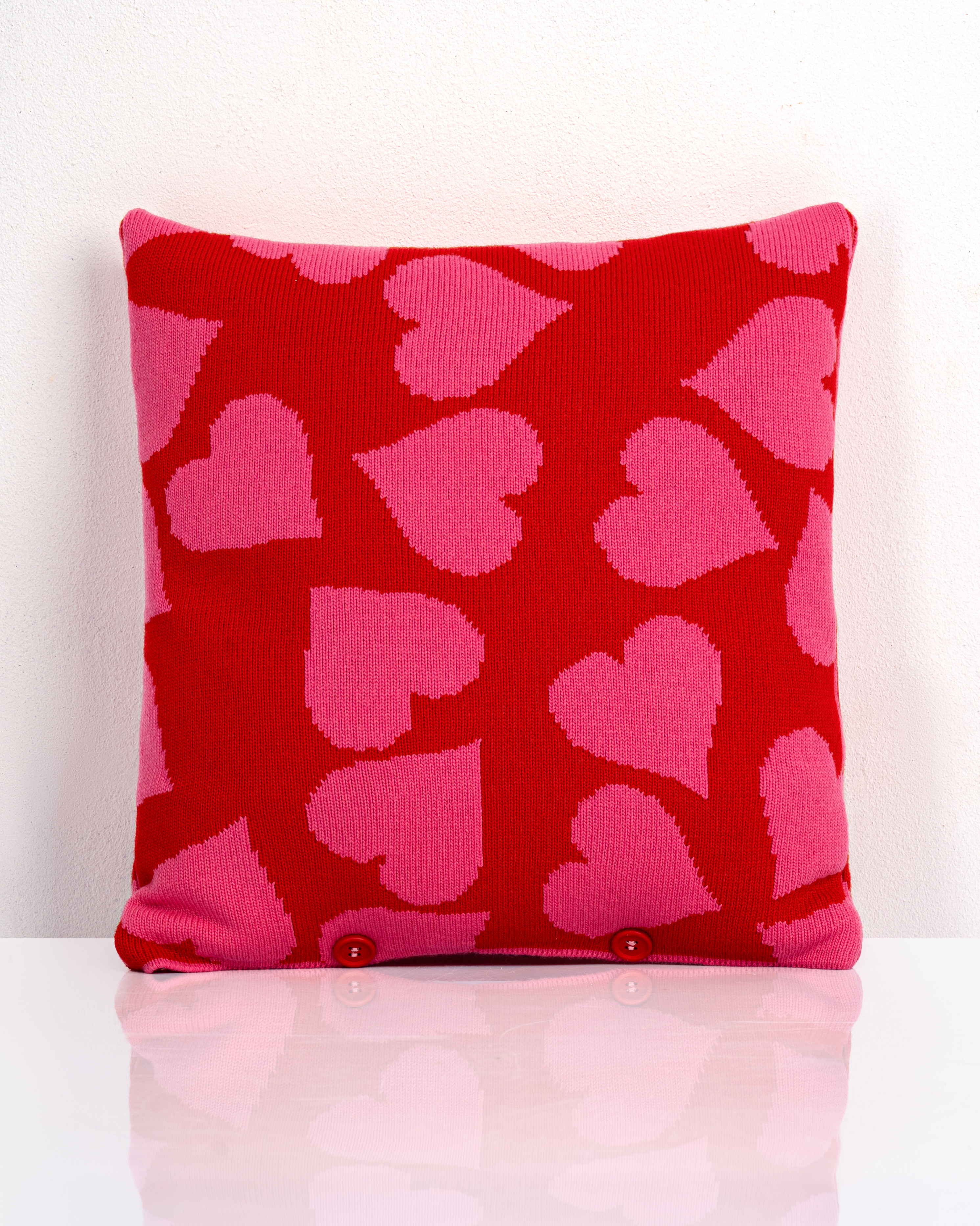 Merinokissen 'Kiss' in Pink und Rot mit gestricktem Herzmuster und Knopfleiste