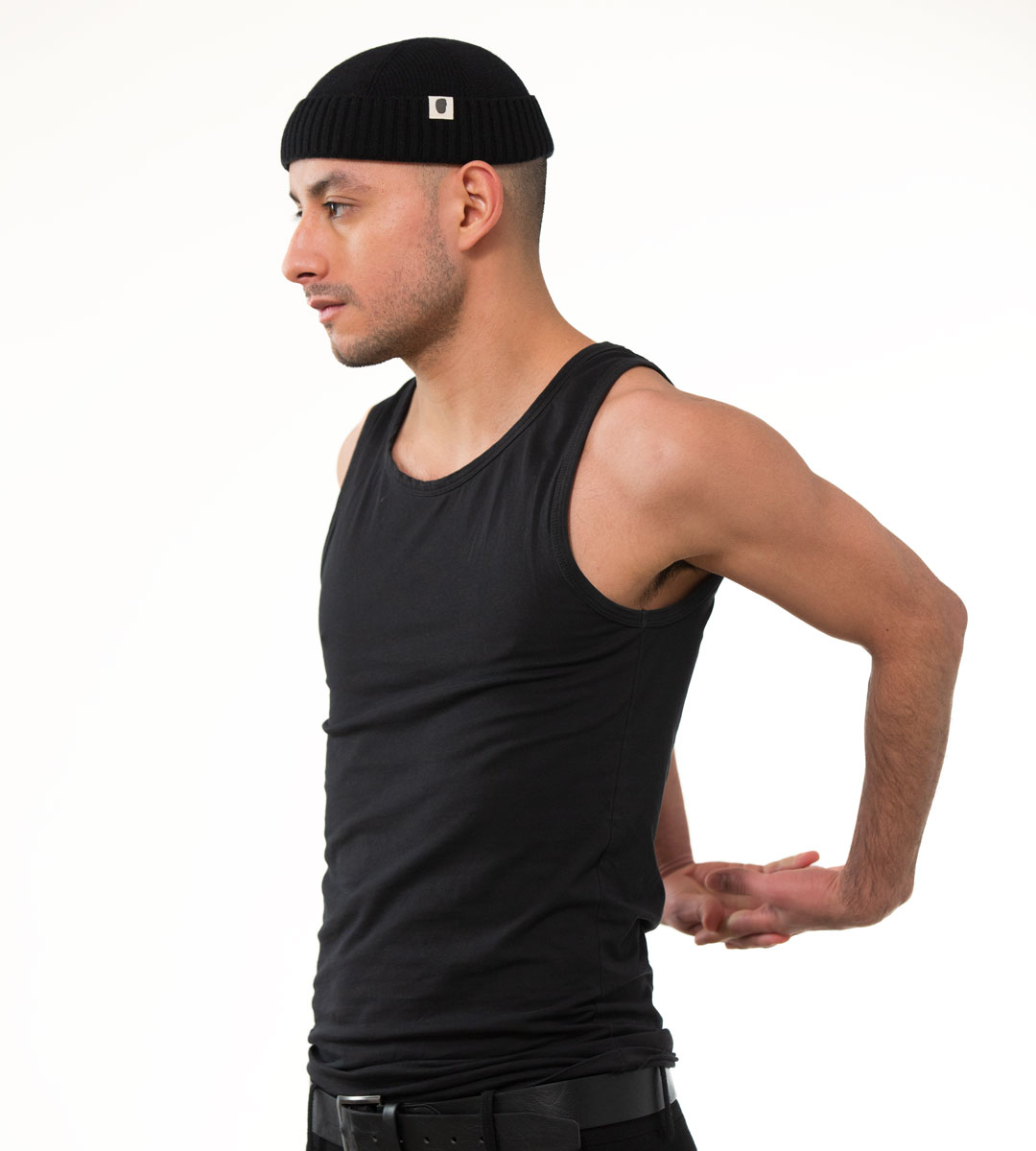 Mann in schwarzem Tank-Top und schwarzer gerippter Docker-Mütze mit Logo-Patch