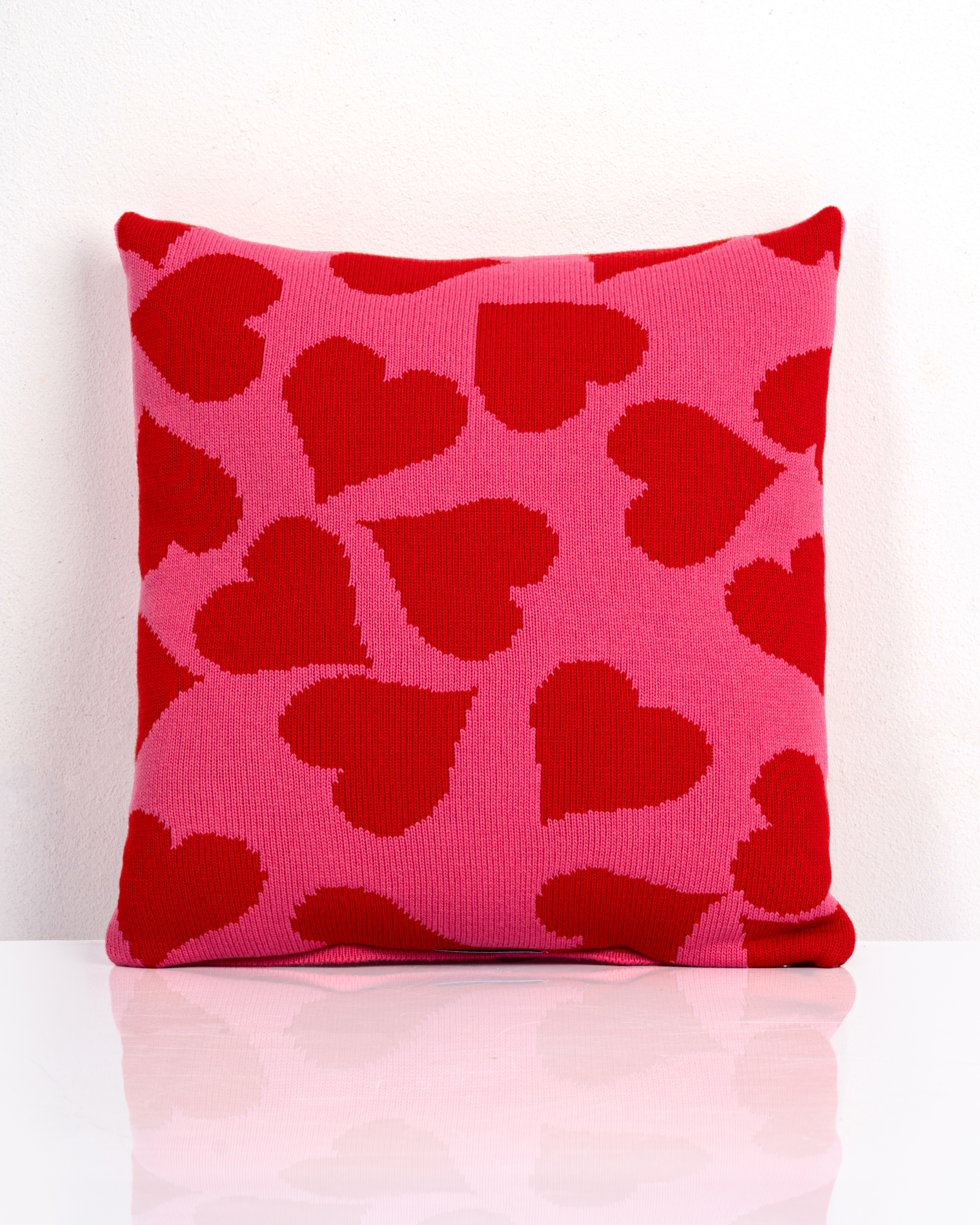 Rosa Strickkissen mit roten Herzen im Allover-Muster