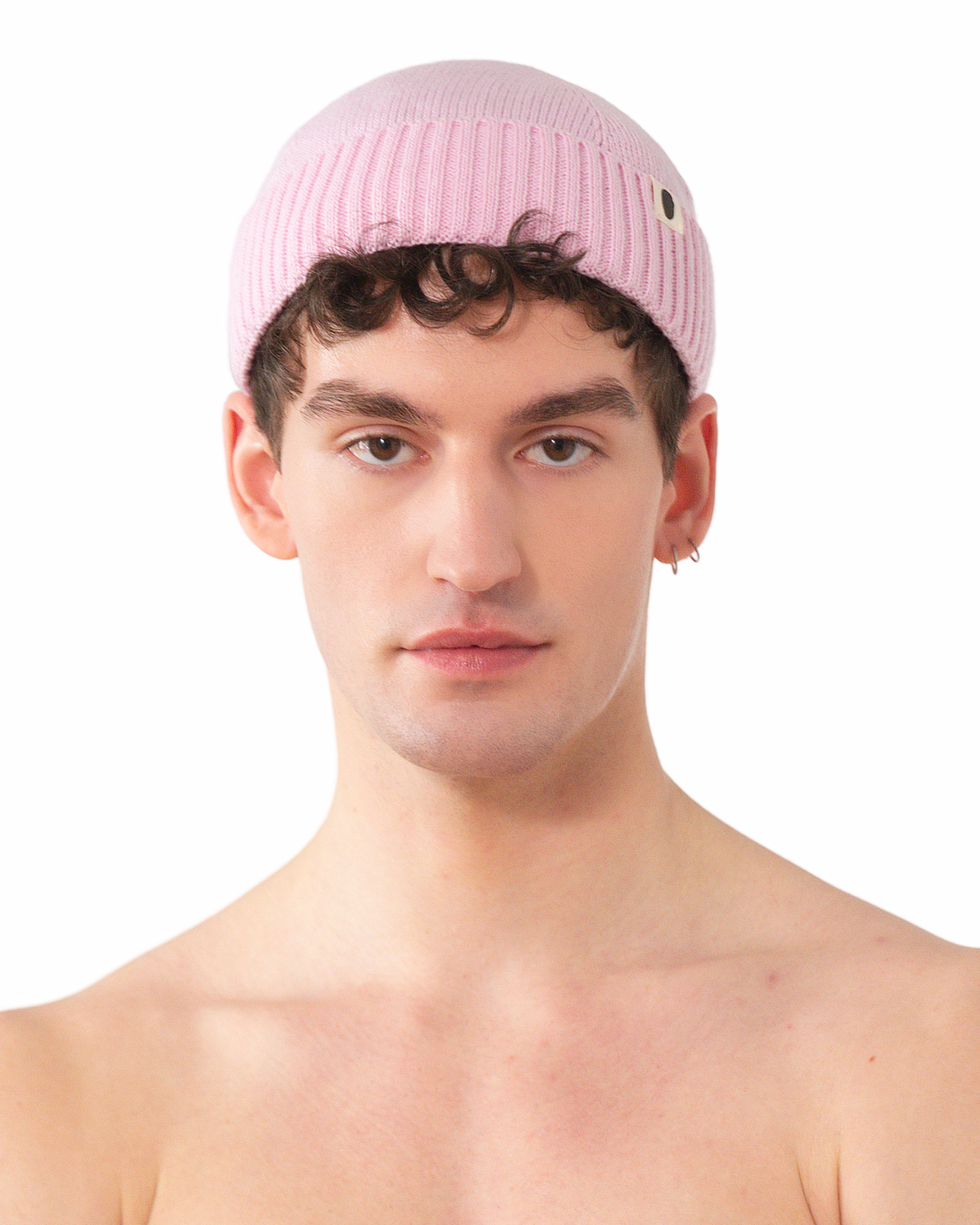 Gerippte Beanie-Mütze in Rosa aus Strick, getragen von einem jungen Mann