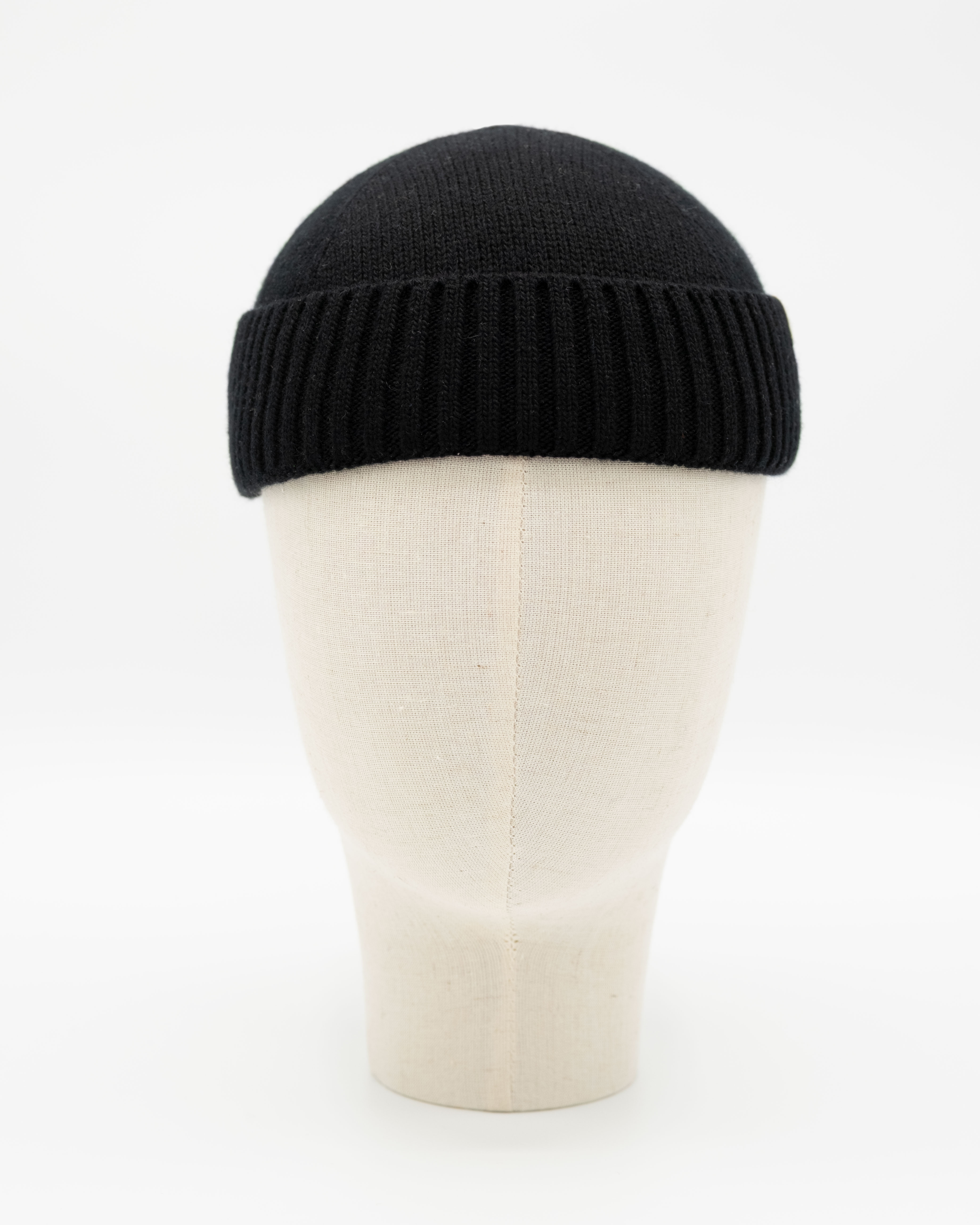 Schwarze Strickmütze mit Rippbund auf einer hellen Schaufensterkopf-Büste