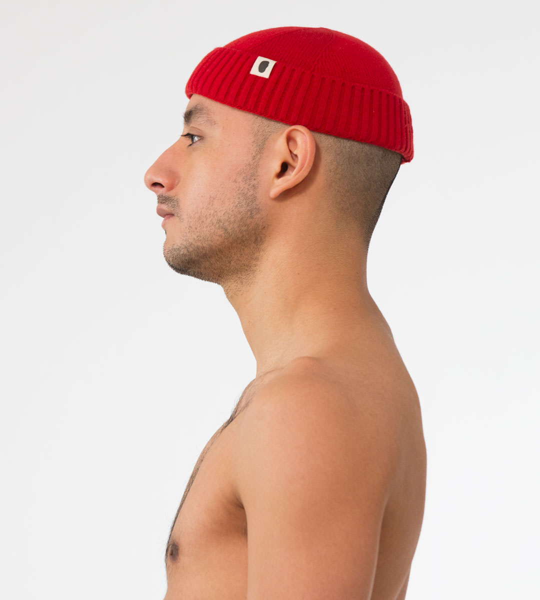 Rote gerippte Dockermütze aus Strickwolle mit kleinem Logo-Patch