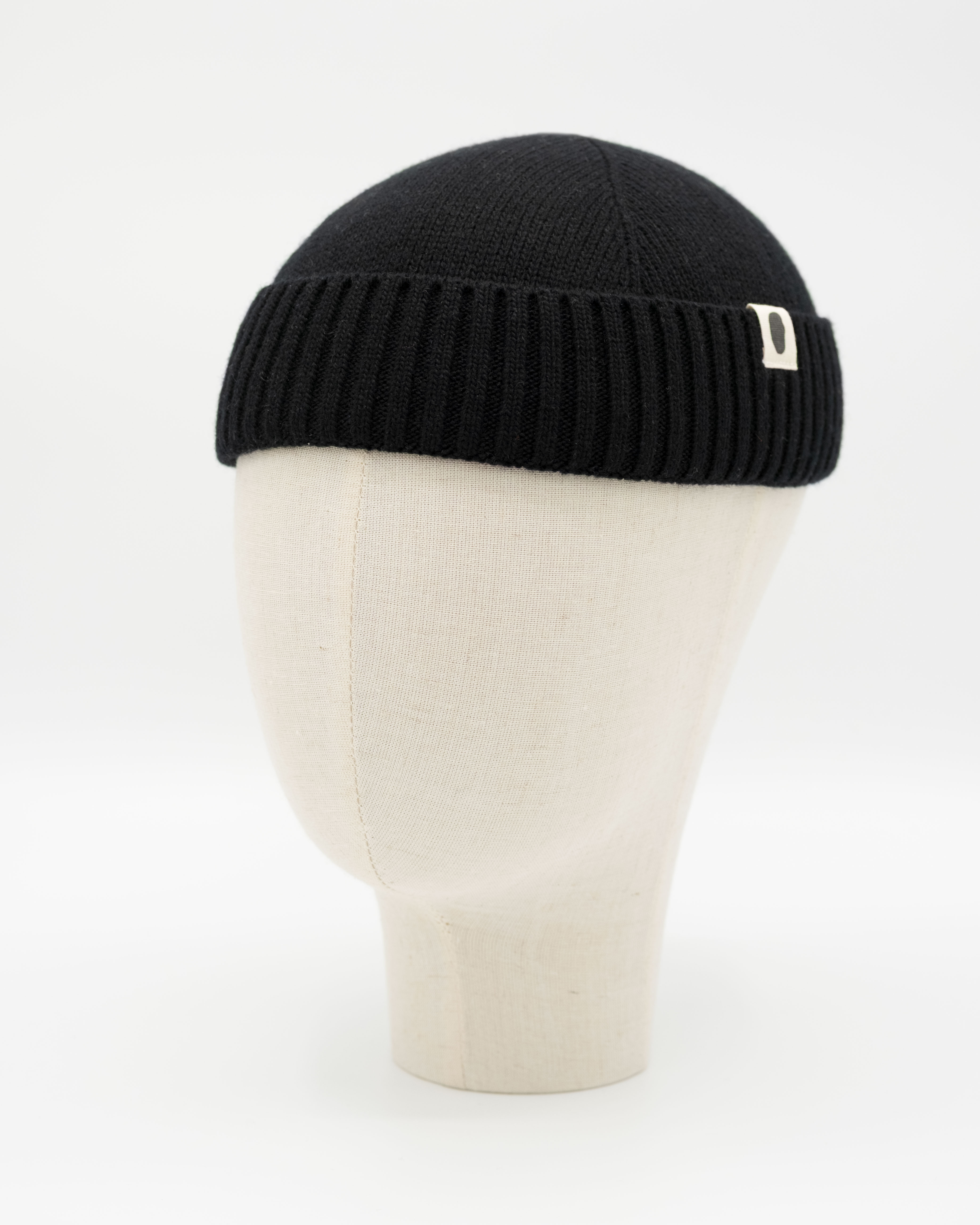 Schwarze Strickmütze im Docker-Stil auf weißem Mannequinkopf
