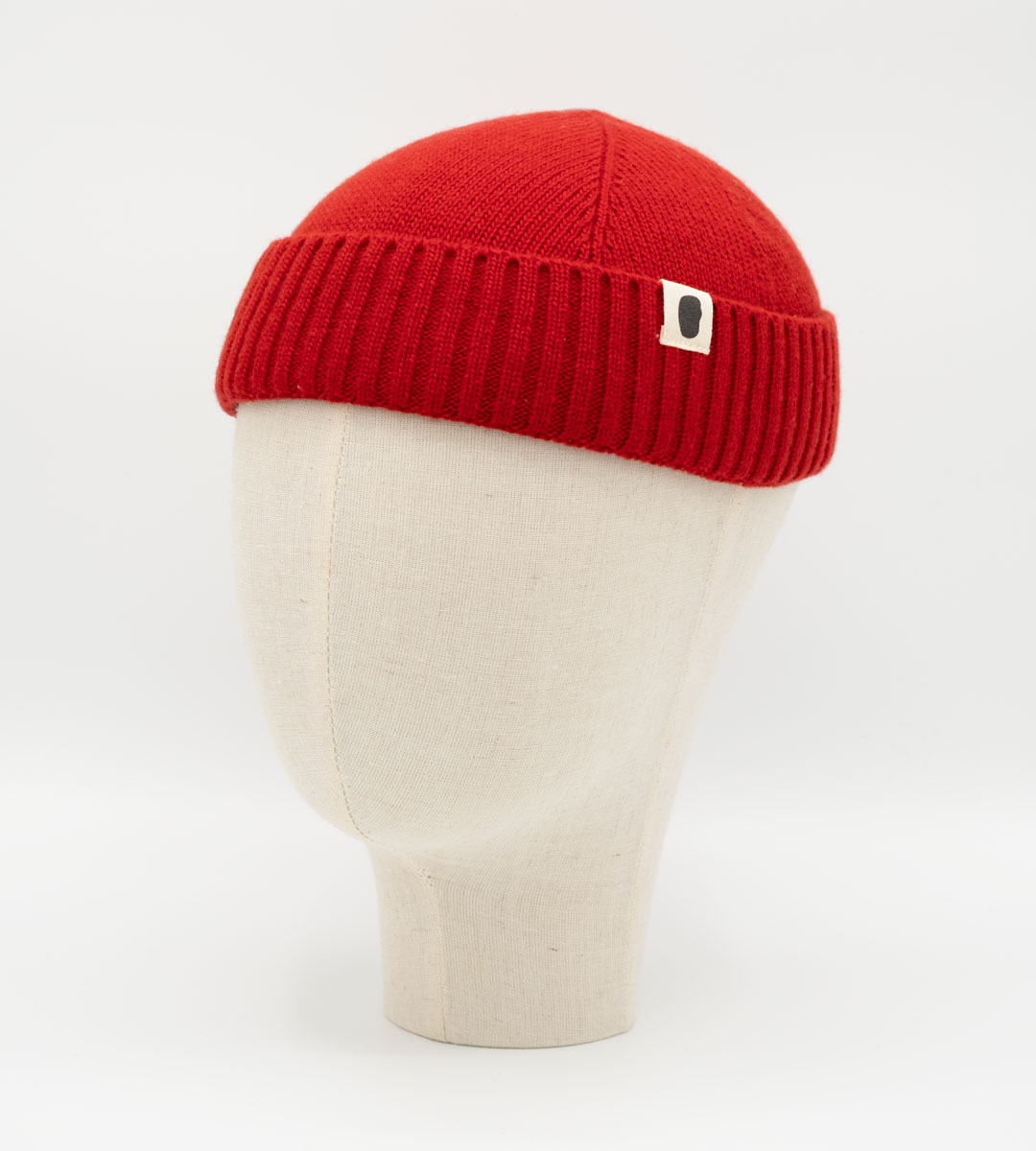 Rote Strickmütze im Docker-Stil mit umgeschlagenem Rippbund auf Mannequinkopf
